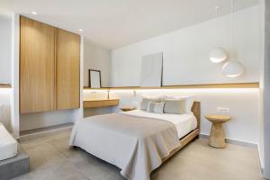a white bedroom with a bed and a cabinet at Kythnos Blue - Suite 1 Sea View, Walk to the beach in Loutra
