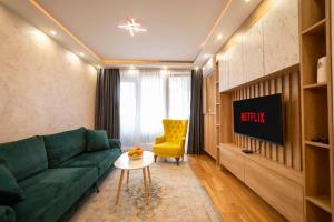 a living room with a green couch and a yellow chair at Apartment 5 Star - Free Parking in Lukavica