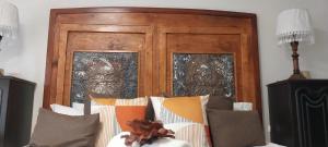 a wooden headboard with two windows in a room at VetraAmour Guesthouse 2 in Kimberley