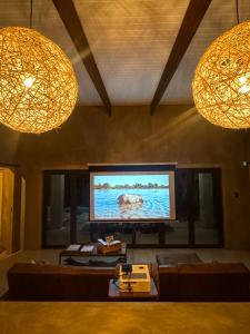 sala de estar con TV de pantalla plana y 2 luces en Shongololo Bush Villa, en Marloth Park