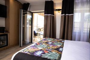 una camera da letto con un letto con una coperta colorata sopra di Auberge De Saint-Rémy - Restaurant Gastronomique a Saint-Rémy-de-Provence