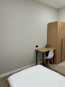 Dormitorio con escritorio, cama, escritorio y silla en Uide hotel, en Almaty