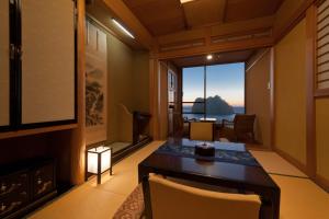 ein Esszimmer mit Tisch und Blick auf das Meer in der Unterkunft Umibenokakureyu Seiryu in Nishiizu