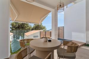 Un comedor con mesa y sillas en un balcón. en Mella Roa - Ivory, en Nydri