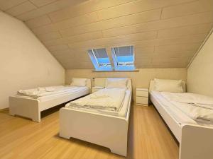 two beds in a room with two windows at WA1002 Geräumige Monteurwohnung Übergangswohnung in Wackersdorf