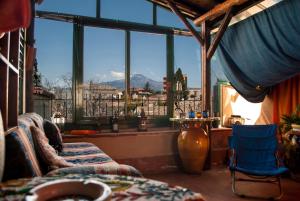 マスカルチーアにあるEtnica Penthouseの山の景色を望む大きな窓が付いた客室です。