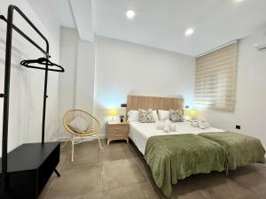 a bedroom with a large bed and a chair at New Víctor Villegas Auditorium y FICA AP2 in Murcia
