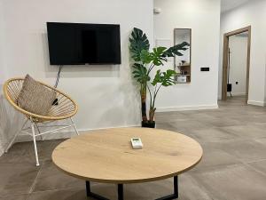 a living room with a table and a chair and a tv at New Víctor Villegas Auditorium y FICA AP2 in Murcia
