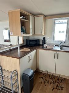 a small kitchen with a sink and a counter at Starview 8 berth Caravan in Chapel Saint Leonards