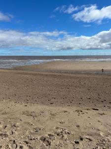 a beach with a person walking on the sand at Starview 8 berth Caravan in Chapel Saint Leonards