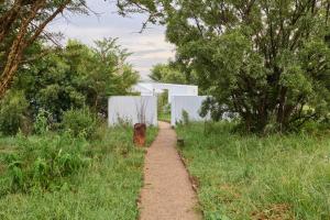 a dirt trail in the middle of a field with trees at FARMHOUSE58 in Krugersdorp