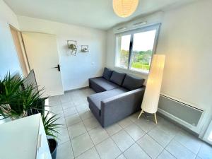 Una sala de estar con un sofá y una ventana. en " Le nid de Peyramont " Centre ville - Balcon - WiFi, en Muret