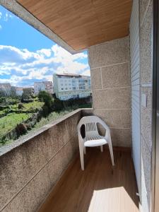una silla blanca sentada en un balcón con vistas en Casa Filo, en Redondela