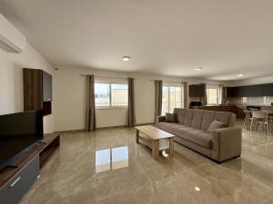 a living room with a couch and a table at New Apartment! Walking distance to the three cities by SF Homes in Tal-Borġ