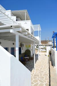 a white house with a patio and a table at Oneiro Rooms Kythnos in Kanala