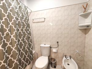 a bathroom with a toilet and a sink and a shower curtain at 4º5 Edificio Mar - Casas & Papeis in Armação de Pêra +15 photos