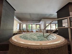 a large jacuzzi tub in the middle of a room at Bassiana Hotel és Étterem in Sárvár