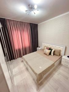 a bedroom with a bed and a ceiling fan at Уютная 2-х комнатная квартира in Taraz