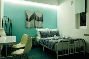 Un dormitorio con una cama con una pared azul. en Green Studio 3 Drama, en Drama