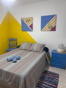 a bedroom with a bed with a yellow wall at El Charco Rooms in Arrecife