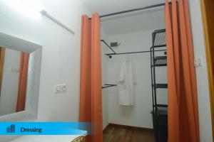 un bagno con tende arancioni e uno specchio di Big Bang Hôtel Behoririka a Antananarivo Altre 19 foto