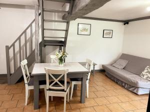 ein Esszimmer mit einem Tisch, Stühlen und einer Leiter in der Unterkunft Gîte authentique à La Ferme du Huaume, animaux admis - FR-1-491-388 in Saint-Lubin-en-Vergonnois + 9 Fotos