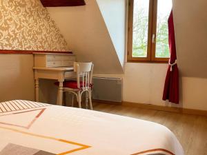 a bedroom with a bed and a desk and a window at Maison de charme avec jardin, animaux acceptés, WiFi - FR-1-491-388 in Saint-Lubin-en-Vergonnois