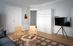 a living room with a tv and two chairs and a table at Gamla Stan Apartments in Stockholm