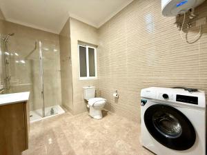 a bathroom with a toilet and a washing machine at New Apartment! Walking distance to the three cities by SF Homes in Tal-Borġ +7 photos