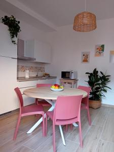 Villa Fossi Rosa Antico, Florence countryside في كالينسانو: مطبخ مع طاولة وكراسي وردية في الغرفة +9 صور