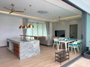 a living room with a table and a couch at Sunterra villa Seaview in Amphoe Koh Samui