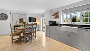a kitchen with a table and a dining room at Vine Cottage in Campden Station