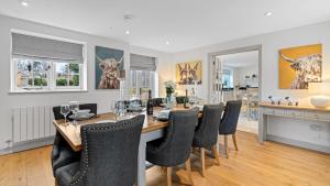 a dining room with a long table and chairs at Vine Cottage in Campden Station
