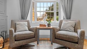 two chairs and a table in a room with a window at Vine Cottage in Campden Station