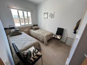 a room with two beds and a chair in it at Villa Rey in Alcanar +49 photos