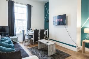 a living room with a couch and a table at Contemporary 2-Bedroom Apartment with 4 Beds, Free Parking, Extended Stay Savings in Birkenhead