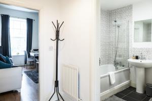 a bathroom with a bath tub and a sink at Contemporary 2-Bedroom Apartment with 4 Beds, Free Parking, Extended Stay Savings in Birkenhead