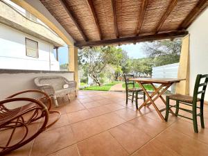 a patio with a table and chairs and a table and chairs at Le Corti Sarde On The Beach in Bari Sardo