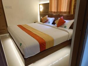 une chambre avec un grand lit avec des oreillers colorés dans l'établissement Attukad river side 4 Rooms Individual Cottage 'near attukad waterfalls' - Hall, 4bed room delux, falls view, located at tea etstae, à Devikolam