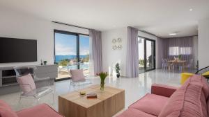 un soggiorno con divano rosa e TV di Villa Aurora a Dolac