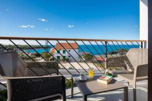un balcone con sedie e un tavolo con vista sull'oceano di Villa Aurora a Dolac