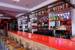 a bar with a red counter and shelves of alcohol at Yeoville Hotel in Johannesburg
