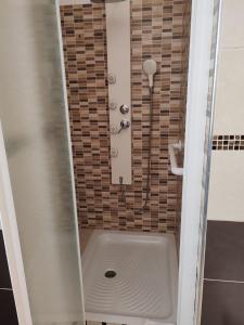 a shower with a hose in a bathroom with a tub at Relax & Fun home in Sìnnai +5 photos
