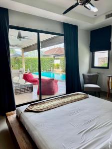 a bedroom with a large bed and a swimming pool at Stunning 2-Bedroom Pool Villa in Ban Thalat Choeng Thale +7 photos