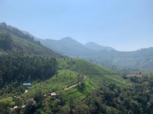 une vue aérienne sur une vallée dans une montagne dans l'établissement Attukad river side 4 Rooms Individual Cottage 'near attukad waterfalls' - Hall, 4bed room delux, falls view, located at tea etstae, à Devikolam