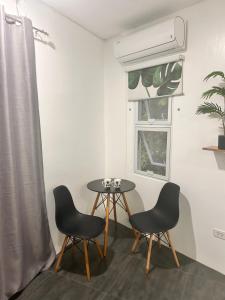 a table and two chairs in a room with a window at White house panglao in Panglao +7 photos