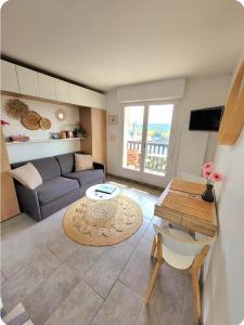 una sala de estar con un sofá y una mesa en M2M Studio magnifique vue mer - avec balcon - les pieds dans l eau!, en Blonville-sur-Mer