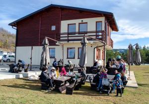 a group of people sitting at tables in front of a building at Resort Stari Bagrem Tvrdimici in Tvrdimići