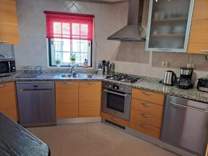 a kitchen with a sink and a stove at Sunset Apartment in Porches