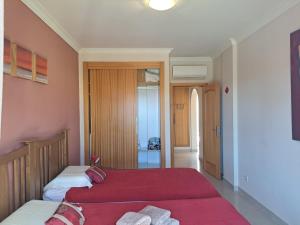 two beds in a room with pink walls at Sunset Apartment in Porches +12 photos